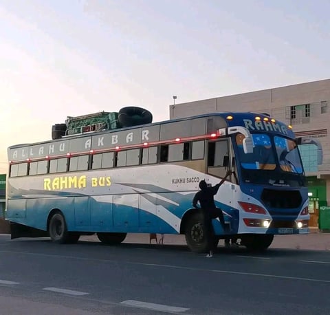 Blue and white double-decker bus with RAHMA BOS branding parked on a street